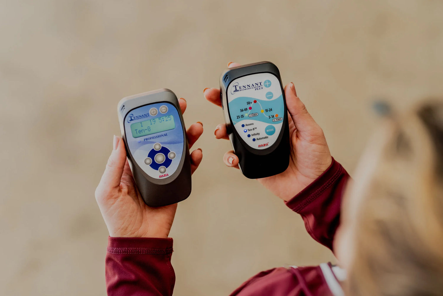 woman holding both the biomodulator pro and plus