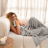 photo of a woman cuddled up with the silver sage throw 